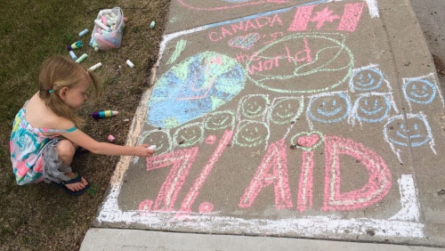 Girl draws on sidewalk with chalk